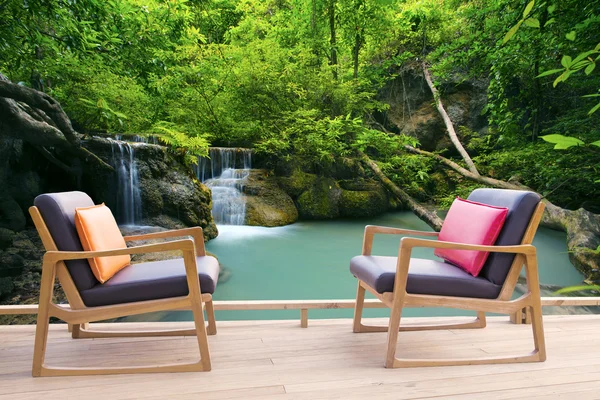Relaxing wooden desk on wood terrace against beautiful waterfall — Stock Photo, Image