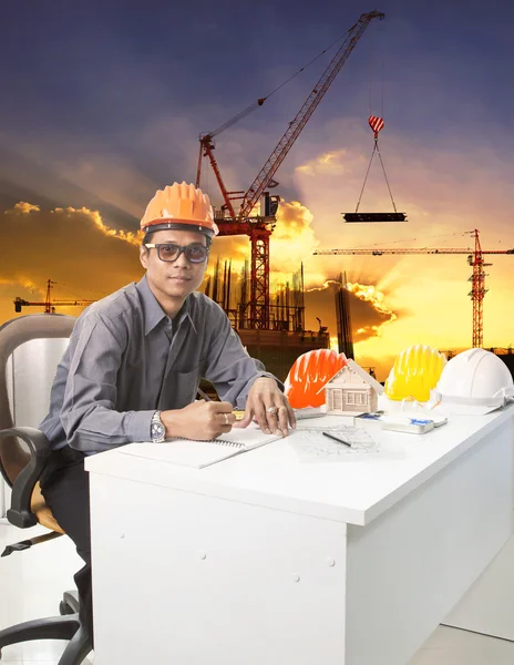 Engineering man met veiligheid helm werktafel tegen ingebouwde — Stockfoto