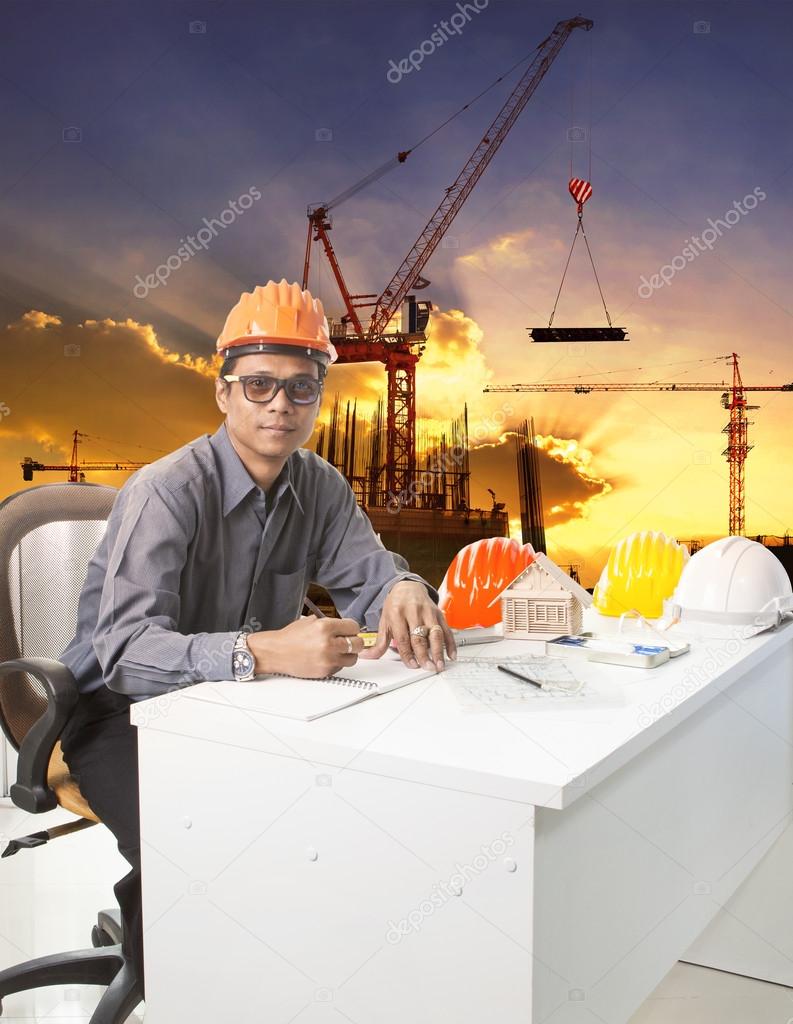 Engineering man with safety helmet working table against buildin