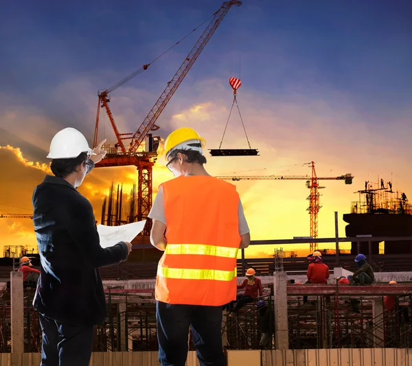 Engineering man working in building construction site with worke — Stock Photo, Image