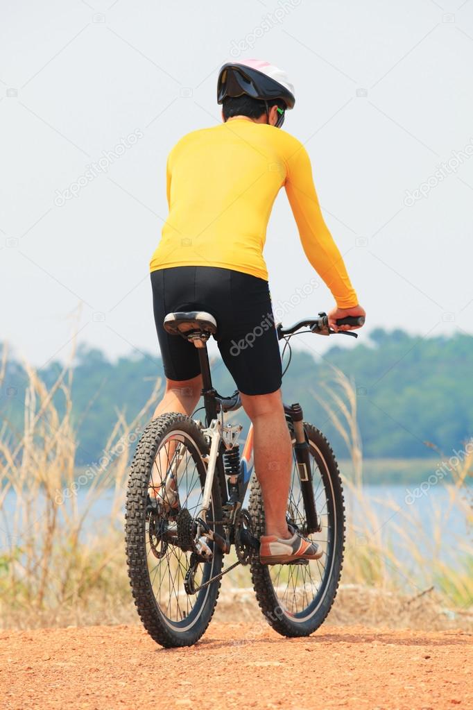 rear view of young bicycle man wearing rider suit and safety hel