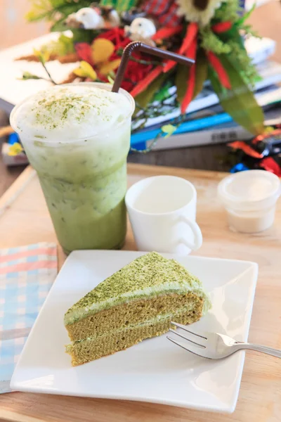 Piece of green tea cake and cool green tea ice in glass bottle a — Stock Photo, Image