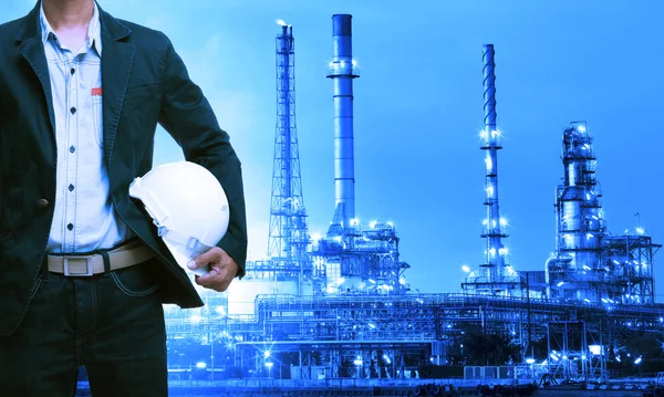 Engineering man and safety helmet standing against oil refinery — Stock Photo, Image
