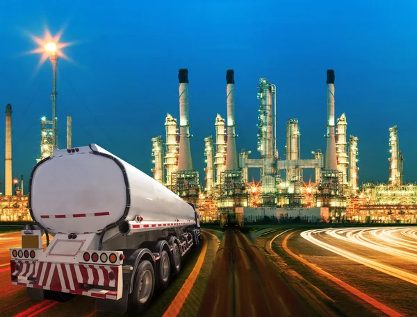 Aardolie container vrachtwagen en mooie verlichting van olieraffinaderij — Stockfoto