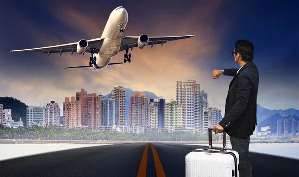 Mann mit großem Gepäck steht auf Gleis und beobachtet Flugzeug — Stockfoto