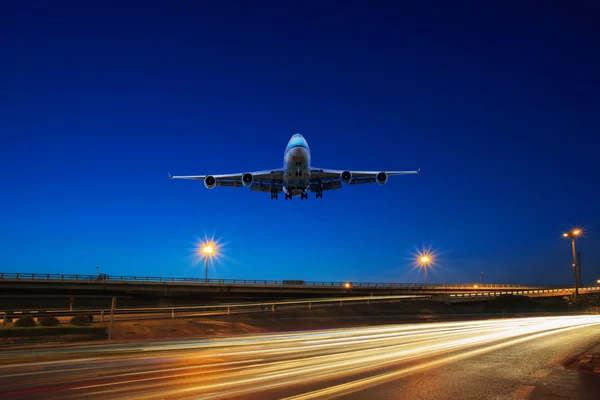 Létající osobní proudové letadlo nad semafor na expresní způsoby u — Stock fotografie