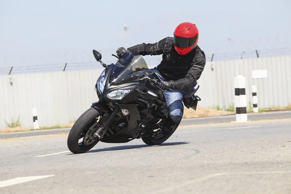 Mladý muž bezpečnostním obleku a červené proti zaklepat jezdecké helmy — Stock fotografie