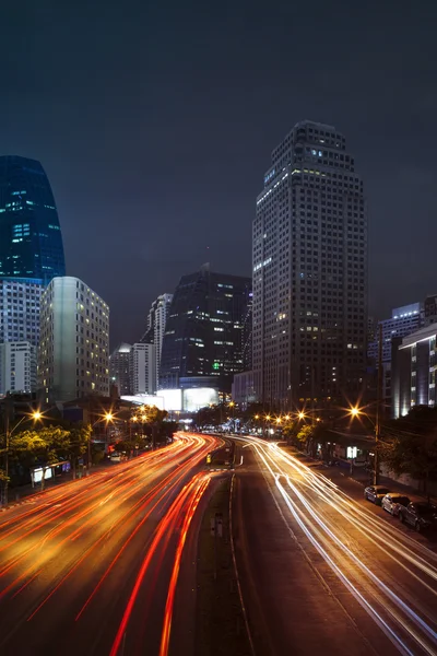 Vehicle lighting on urban road and building against night scene — Stock Photo, Image