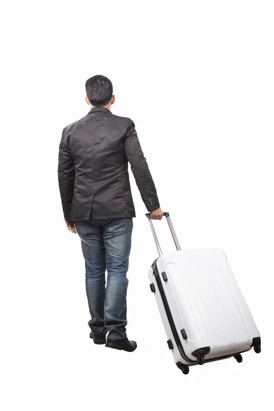 Rear view of young man and pulling belonging luggage walking to — Stock Photo, Image