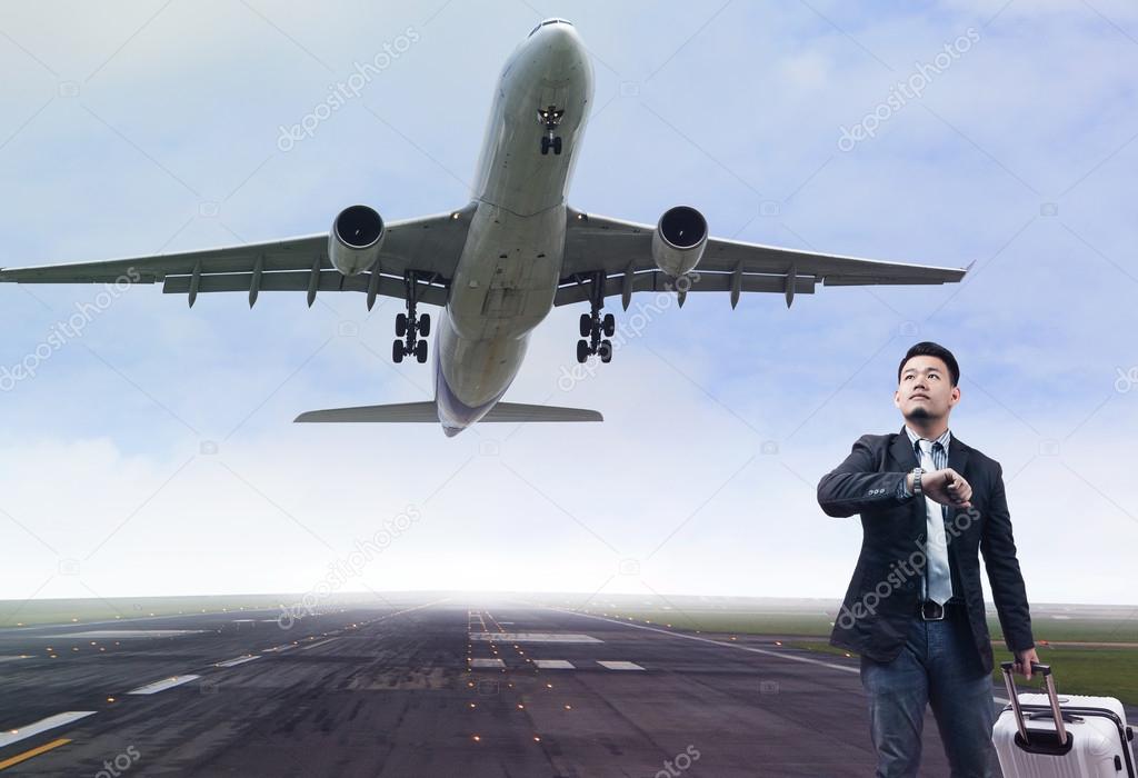 Young business man standing in airport runways with belonging lu
