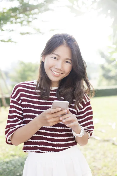 Portrait de belle jeune femme et téléphone intelligent dans la main sourire — Photo