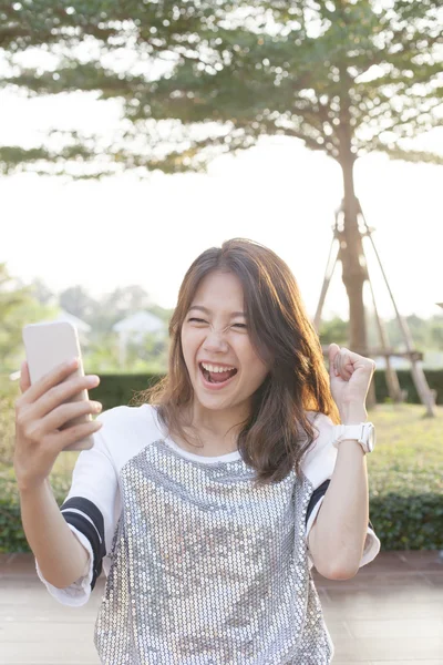 Ritratto di giovane donna che guarda sullo schermo del telefono cellulare con sur — Foto Stock