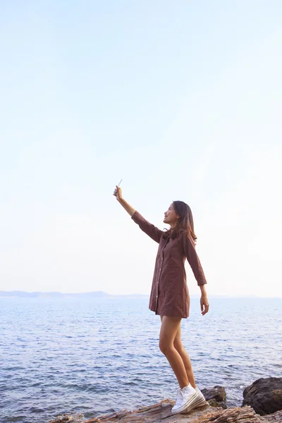 Portrait of young beutiful woman rising up smart phone to sky us — Stock Photo, Image