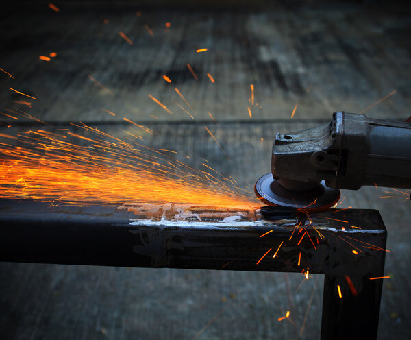 Industrial metal cutting tool in iron factory shop working and cut on steel sheet against beautiful fire sparking