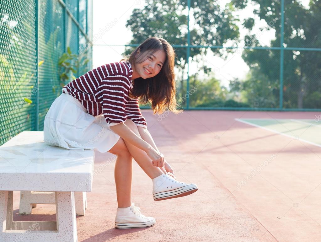 Portrait of beautiful sport girl sitting in tennis courts  looki