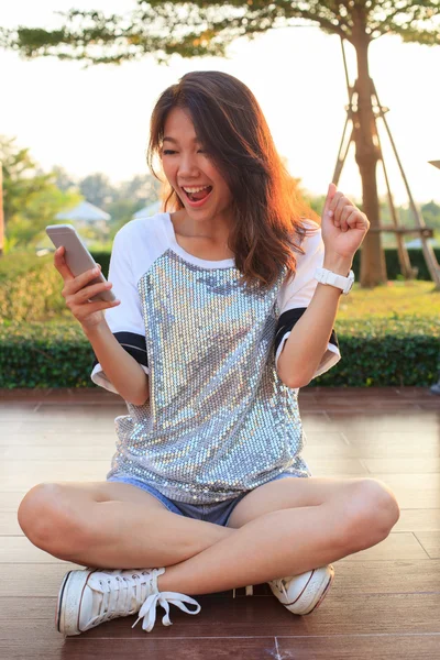 Retrato de mulher jovem assistindo a tela do telefone móvel com sur — Fotografia de Stock