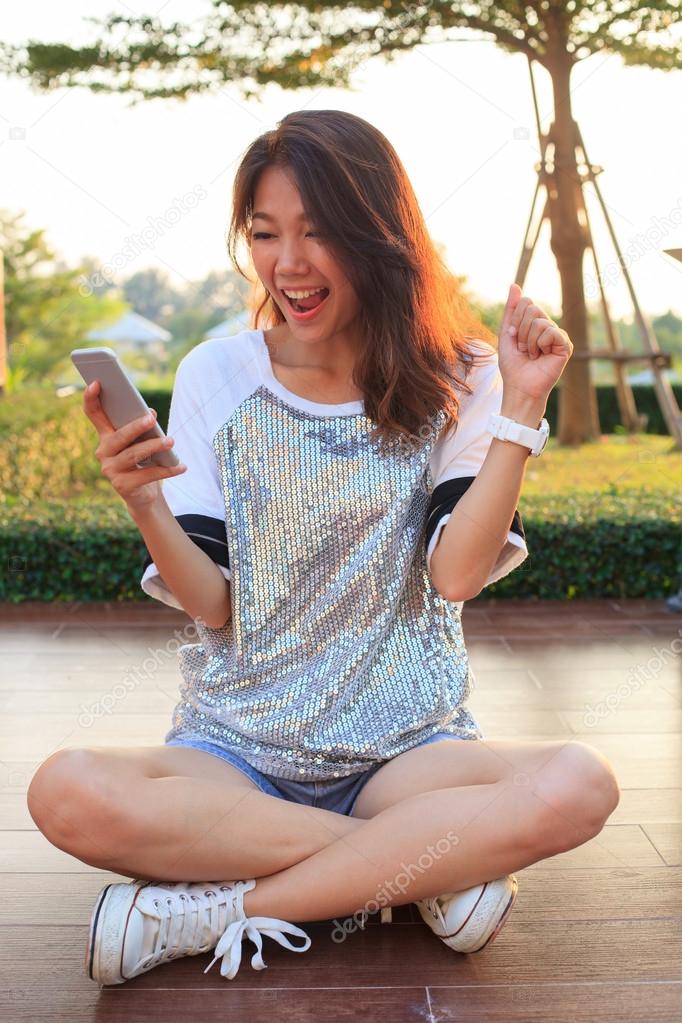 portrait of young woman watching to mobile phone screen with sur
