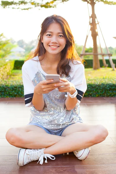 Joven adolescente mujer y teléfono inteligente en la mano sonriendo con feliz emoti — Foto de Stock