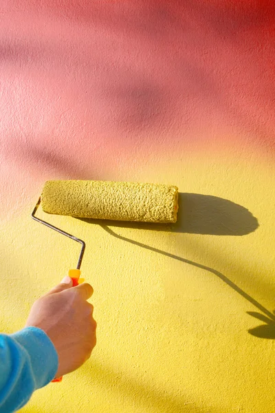 Χέρι ζωγραφική κίτρινο τοίχο από ζωγράφος βούρτσα κυλίνδρων — Φωτογραφία Αρχείου