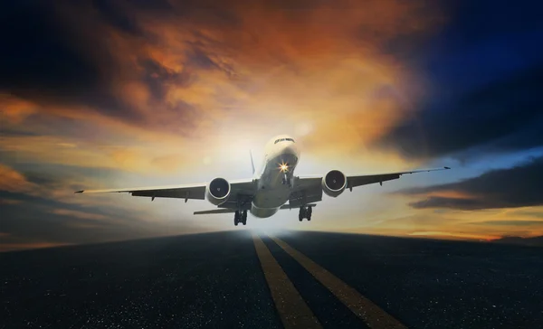 Samolot pasażerski zdjąć z pasów startowych z piękną różową sk — Zdjęcie stockowe