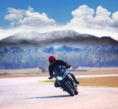 Genç adam dağ hig karşı asfalt yolda motosiklet binme