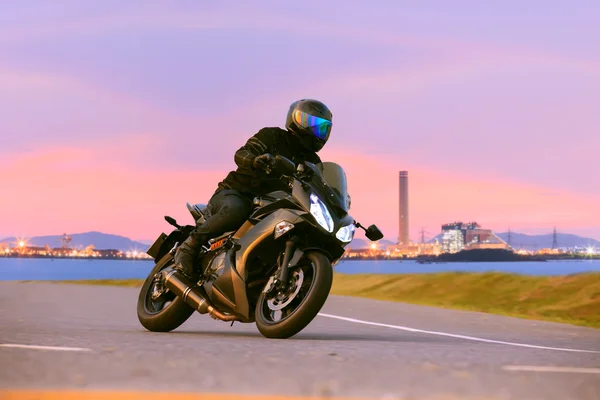 Młody mężczyzna jazdy motocykl sportowo-turystyczny na drogach asfaltowych ag — Zdjęcie stockowe
