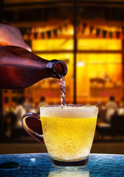 Lager desagüe de cerveza de botella a vidrio en la mesa con li hermosa — Foto de Stock