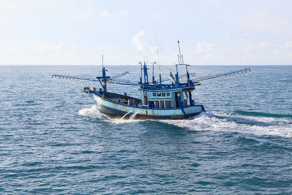 Barco de pesca local que corre sobre a água do mar azul — Fotografia de Stock