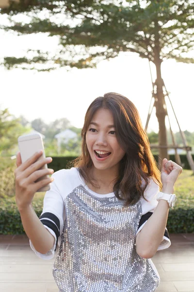 Portrait of young woman watching to mobile phone screen with sur — Stock Photo, Image