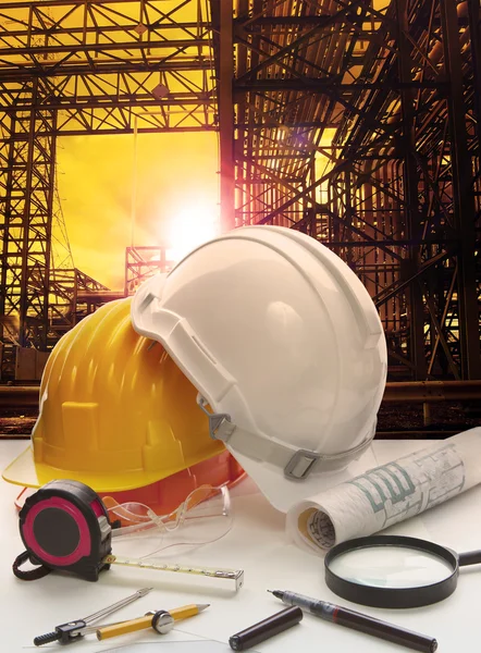 Casco de seguridad en la mesa de trabajo del ingeniero contra la estructura de la tubería — Foto de Stock