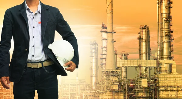 Inženýrské muž a bezpečnostní přilbu, stojící proti ropné rafinerie — Stock fotografie