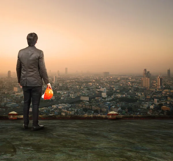 Ingénieur debout sur le dessus du bâtiment regardant vers l'épicerie urbaine — Photo