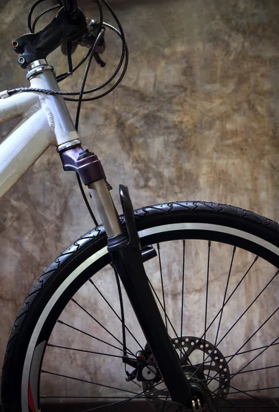 Close up front wheel tire of mountain bike against grungy cement — Stock Photo, Image