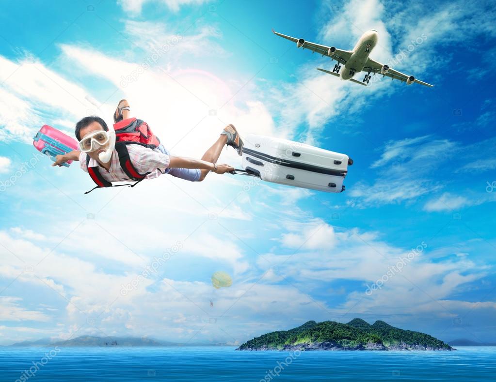 Young man flying on blue sky wearing snorkeling mask and holding