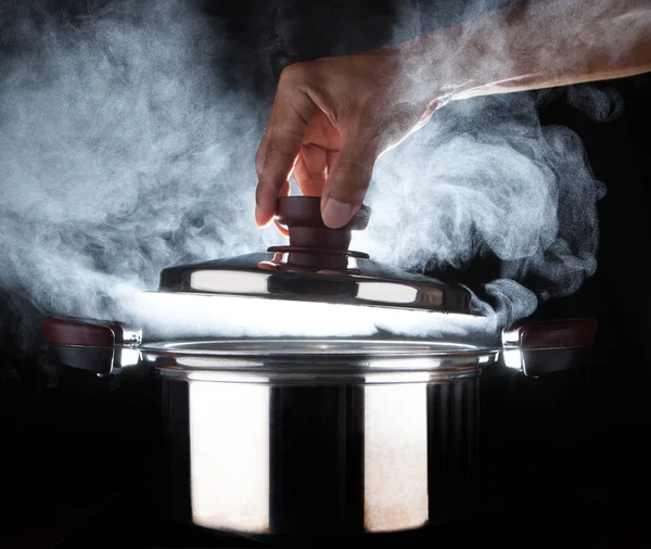 Hand des Küchenchefs öffnet heißen Topf mit schöner Studiobeleuchtung — Stockfoto