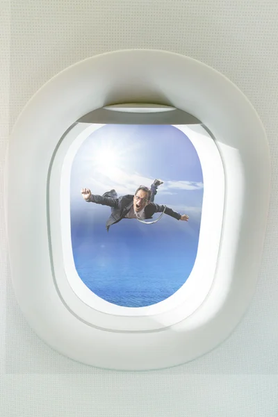 Business man floating mid air out side passenger plane window — Stock Photo, Image