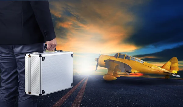 Ο άνθρωπος των επιχειρήσεων με μεταλλικά αποσκευές ισχυρή στέκεται στο αεροδρόμιο runwa — Φωτογραφία Αρχείου