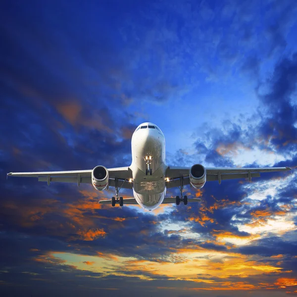 Avião a jacto de passageiros preparando-se para aterrar contra o belo crepúsculo — Fotografia de Stock