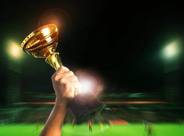 Hand rising soccer football championship cup on sport competiton — Stock Photo, Image