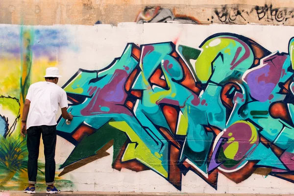 绘画在泰国曼谷的侧路墙上的涂鸦艺术的年轻的泰国男孩彩色喷雾瓶 — 图库照片