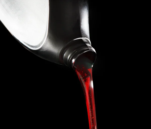 File close up red motor oil pouping from black plastic bottle ag — Stock Photo, Image