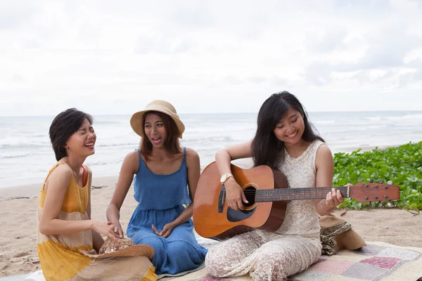 Ritratto gruppo di giovane asiatico donna giocare chitarra in mare spiaggia — Foto Stock