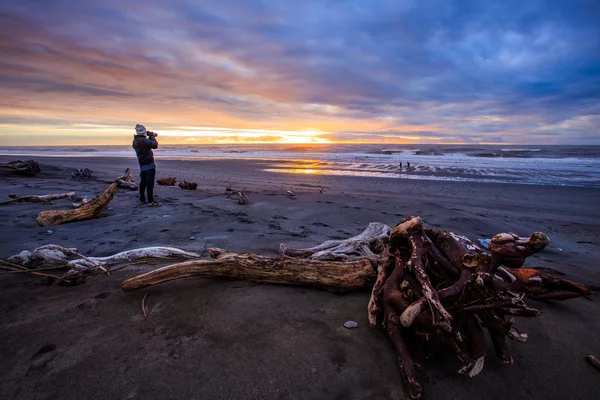 Fotógrafo y puesta de sol en hokitika playa negro isla del sur ne —  Fotos de Stock