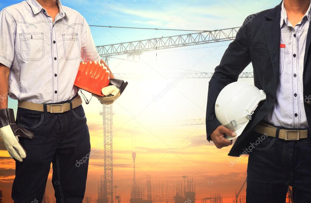 two engineer man working with white safety helmet against crane