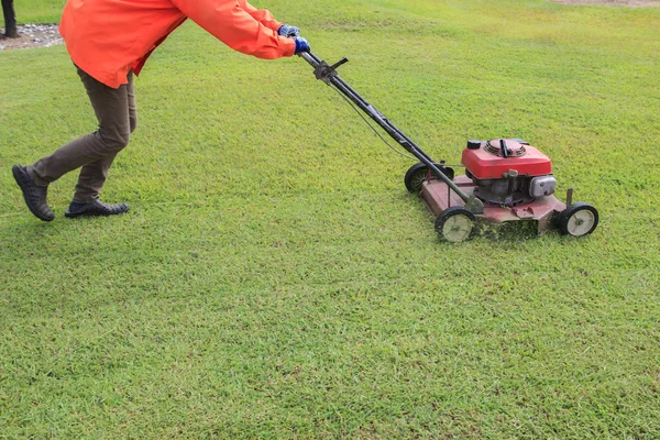 Worker cutting green grass field by engine lawn mover — Stock Photo, Image