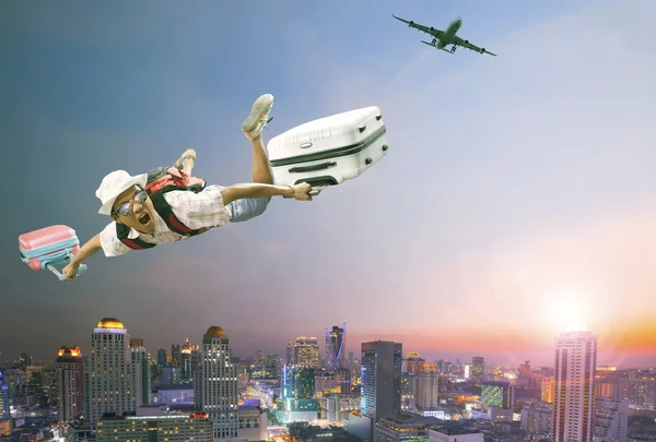 Younger man flying mid air with belonging luggage and passenger — Stock Photo, Image