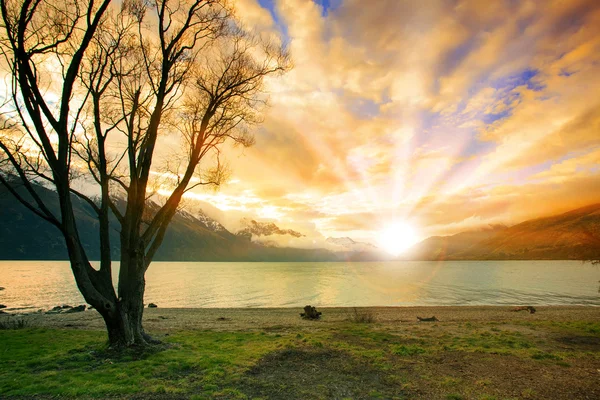 Mark scape av solen gå upp himlen bakom naturliga sjö och snö mounta — Stockfoto