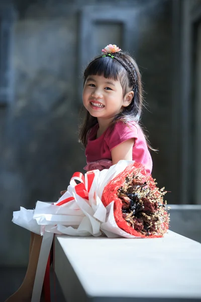 Zubatý usmívající se tvář asijské dítě štěstí emocí a suché květi — Stock fotografie