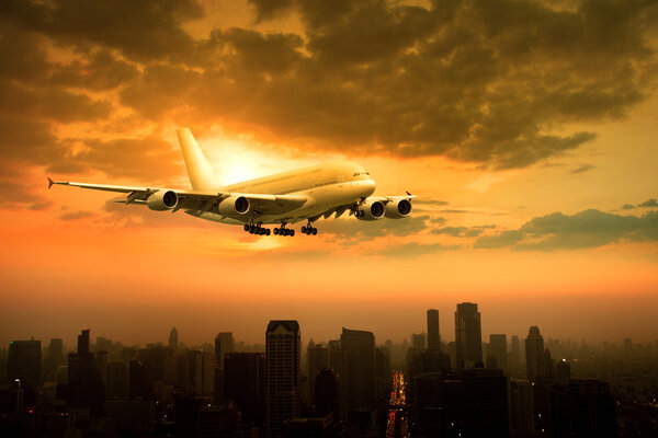 пассажирский реактивный самолет пролетел над городской сценой против красивой su
