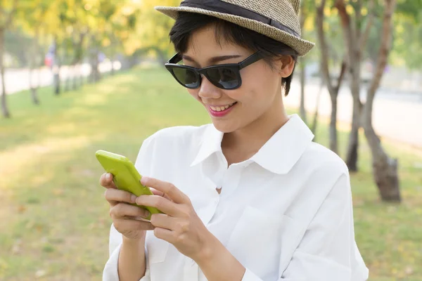 Porträtt av ung vacker asiatisk kvinna och smart telefon i handen — Stockfoto